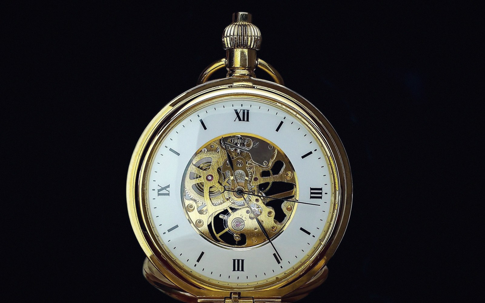 Gold pocket watch with an exposed skeleton dial revealing its mechanical gears