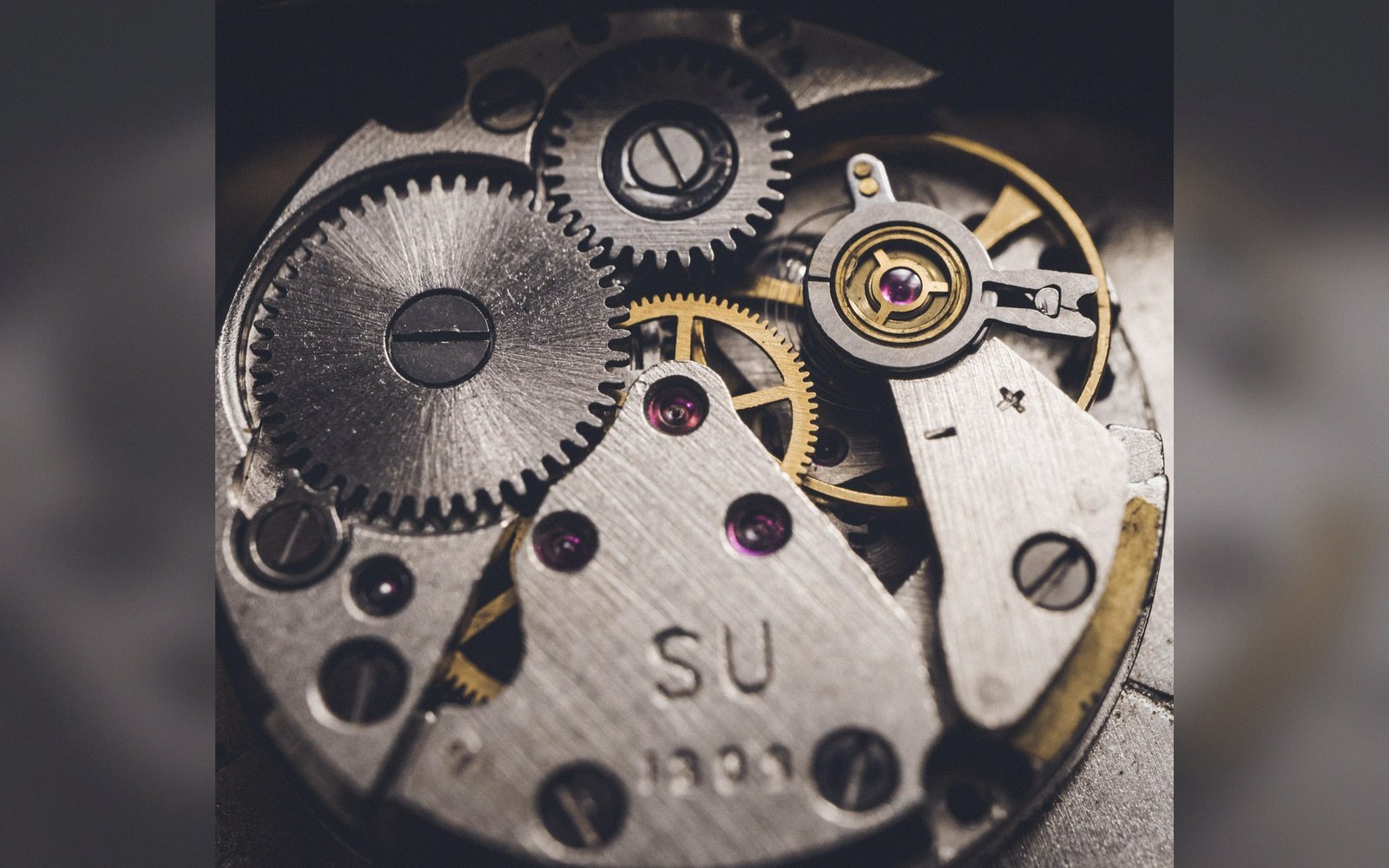 Close-up of a mechanical watch movement with gears, jewels and metal plates